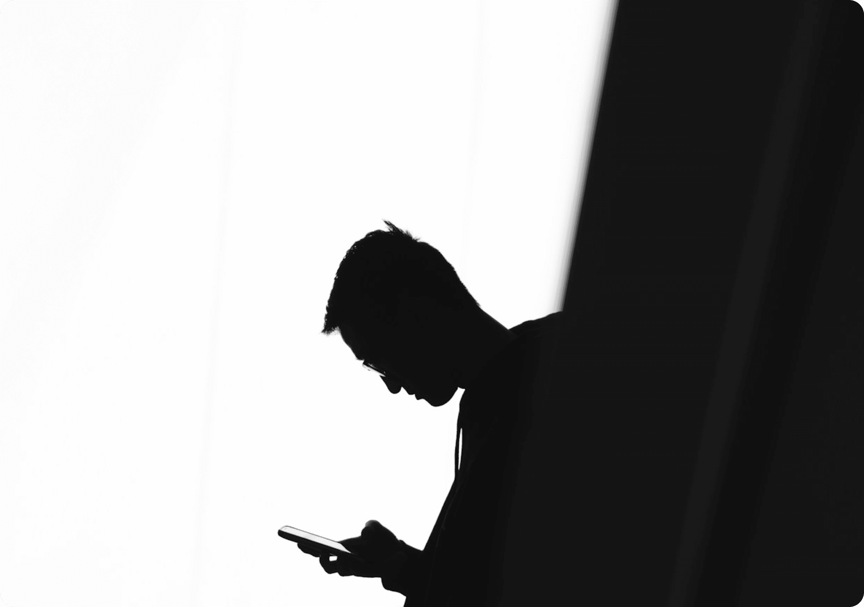 Silhueta de um homem olhando o celular
